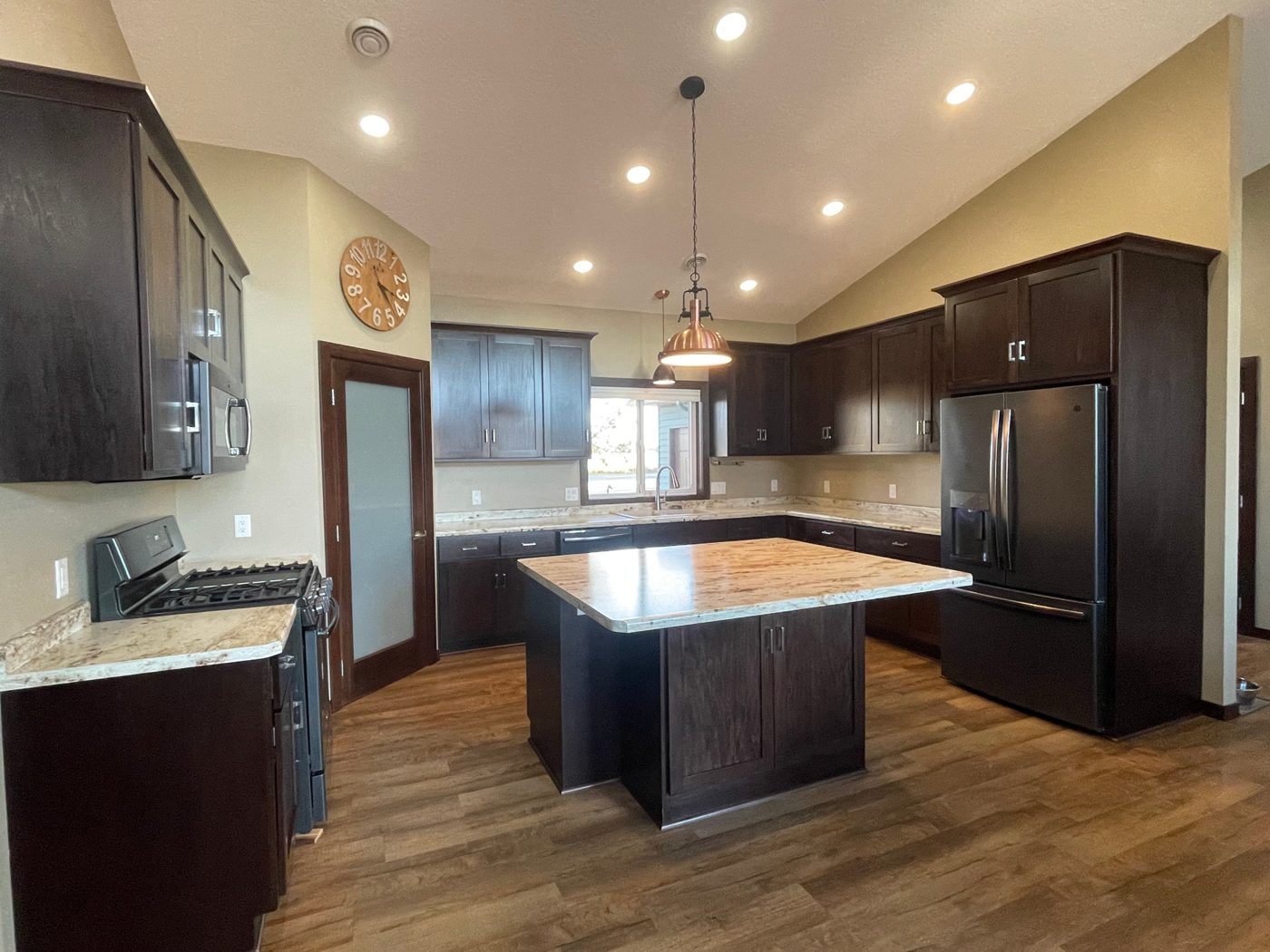The finished kitchen with the range wall, pantry door, and island