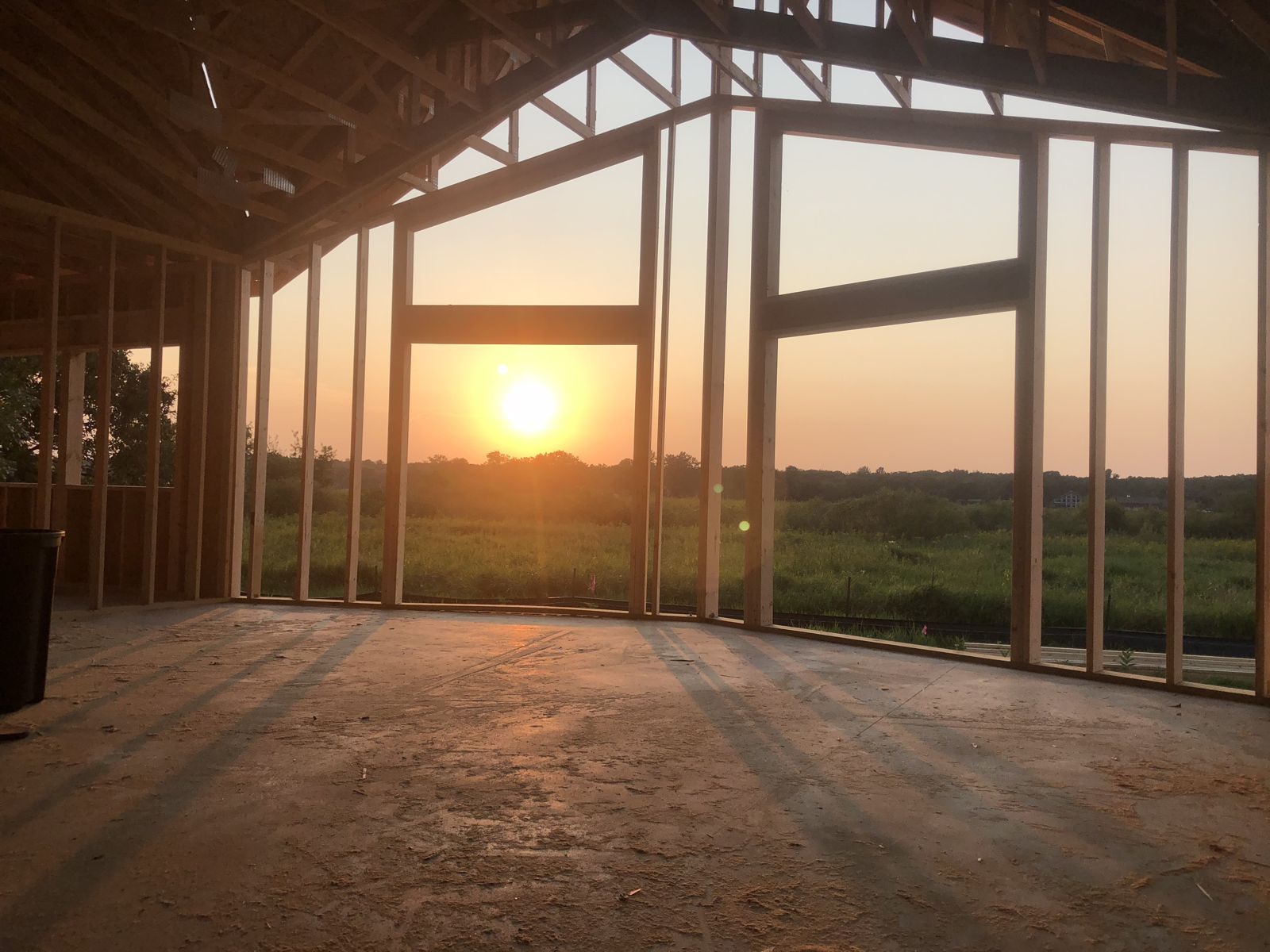 Sunset over the lake seen through the open wall framing of our home during construction